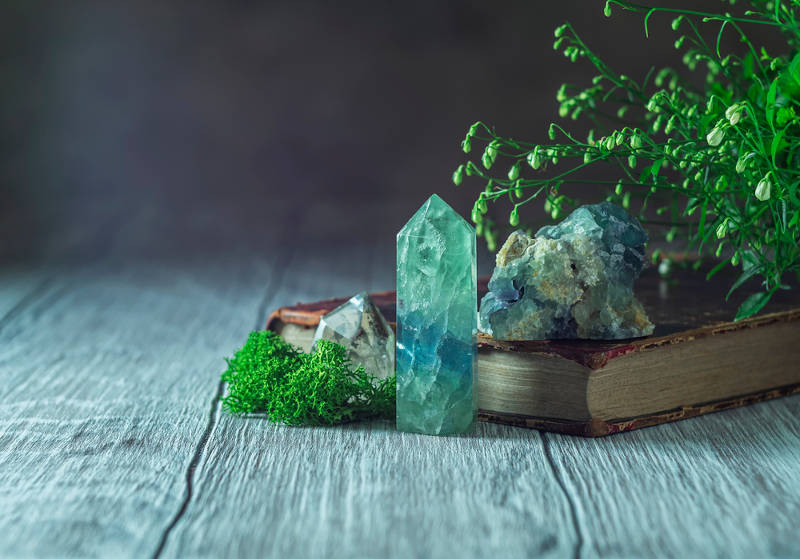 Crystals used for vivid and lucid dreaming on a wooden bench with plants.