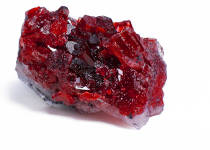 A red garnet crystal on a white background. 