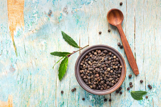 Magical black pepper on a blue wooden table. 