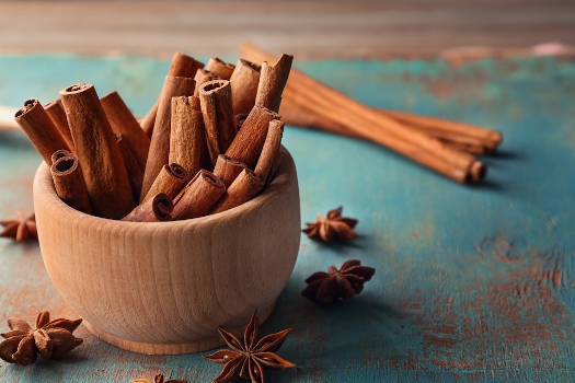 Magical cinnamon sticks in a wooden bowl. 