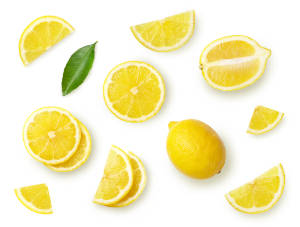 Whole lemons and freshly sliced lemons on a white background. 