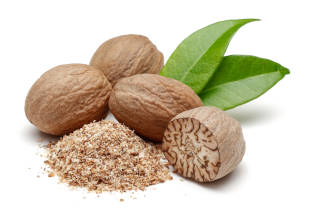 Nutmeg nuts and freshly grinded nutmeg on a white background. 
