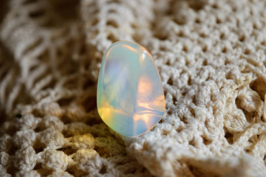 A beautiful opalite stone with magical and metaphysical properties on a blanket. 