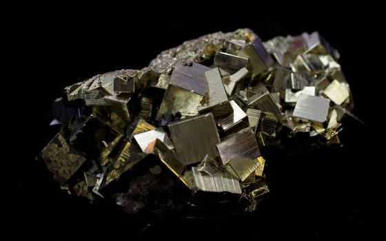 A pyrite stone with magical and metaphysical properties on a black background. 