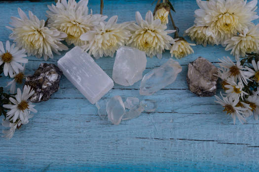 White selenite crystals with magical and metaphysical properties on a blue wooden table. 