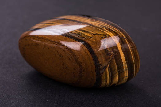A polished tiger's eye gemstone with magical and metaphysical properties. 