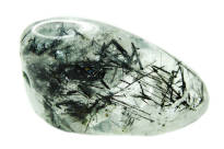A white and black tourmalinated quartz crystal on a white background. 