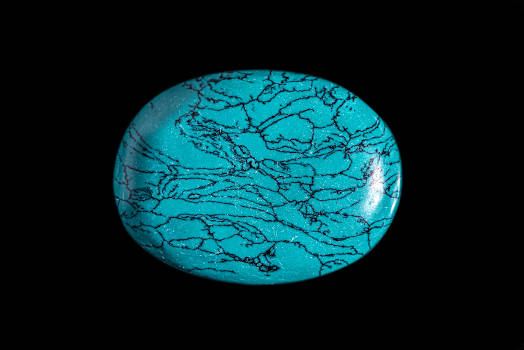 A blue turquoise stone with magical and metaphysical properties on a black background. 
